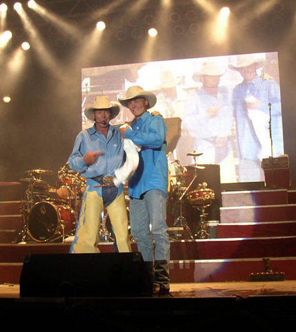 In this 2003 photo, Chris LeDoux, at left, stands with his son, Ned, during a concert in California.