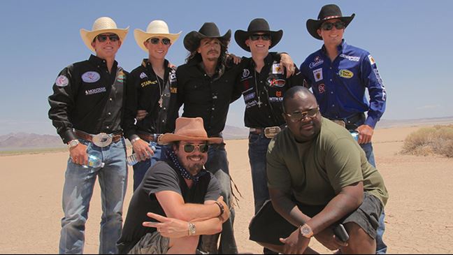 Steven Tyler (center) with PBR cowboys and Jared Gutstadt (left front) and Poo Bear (right front).
