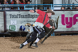 Tate Rhoads battles his bull during Friday's qualifier round. (TODD BREWER PHOTO)